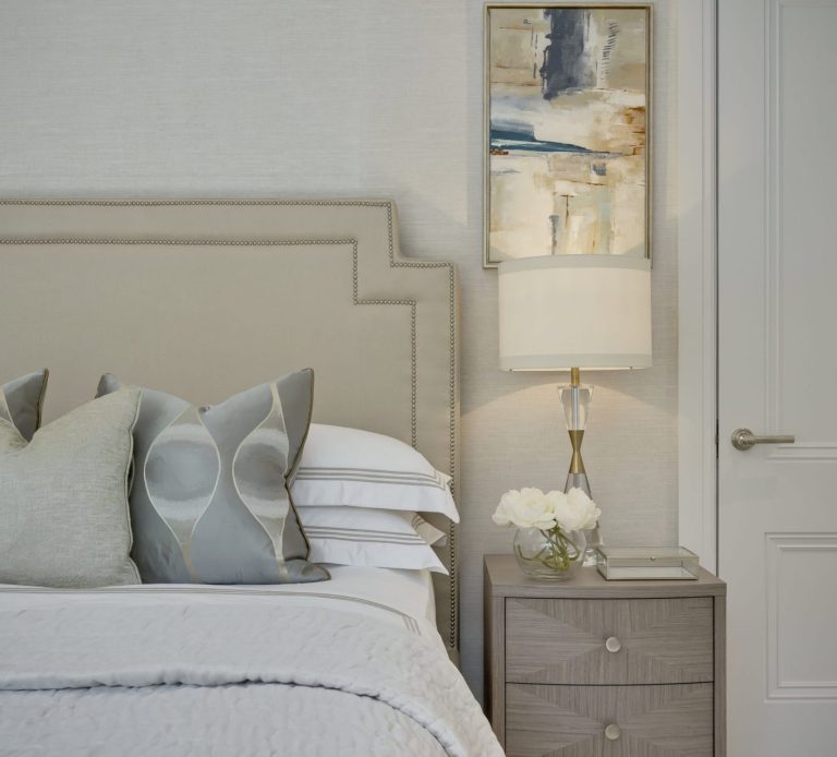 Neutral luxury bedroom interior design featuring a bespoke beige studded headboard, textured wallpaper, and elegant bedside styling in a Guildford home luxury-bespoke-headboard-bedroom-styling-surrey